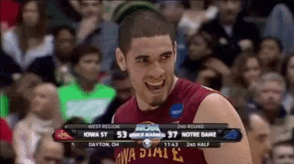 a basketball player wearing a iowa state jersey is smiling in front of a crowd