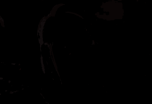 a woman wearing glasses is covering her face with her hand while sitting on a couch .