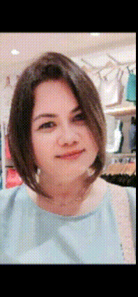 a woman with short hair and a blue shirt is smiling for the camera