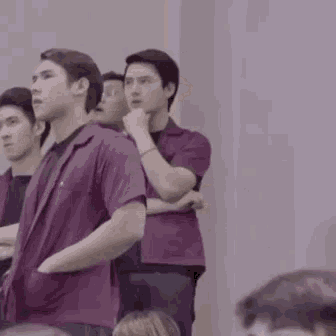a group of young men are standing in a row in a room .