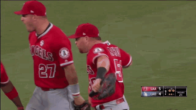 two baseball players for the angels are standing on a field