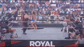 a group of people are wrestling in a ring with a crowd watching .