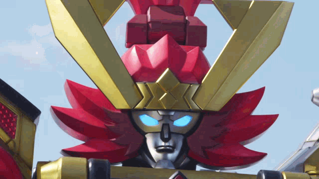 a red and gold robot with blue eyes and a star on top