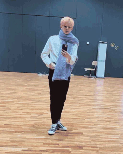 a man with pink hair is taking a selfie in a gym