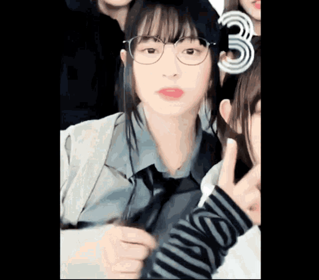 a girl wearing glasses giving a peace sign