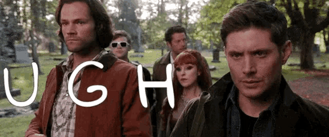 a group of people standing next to each other in a cemetery with the word ugh written on the bottom .