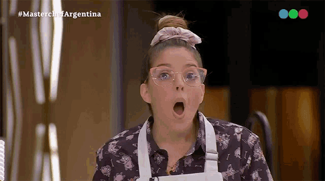 a woman wearing glasses and an apron looks surprised in a masterchef argentina advertisement