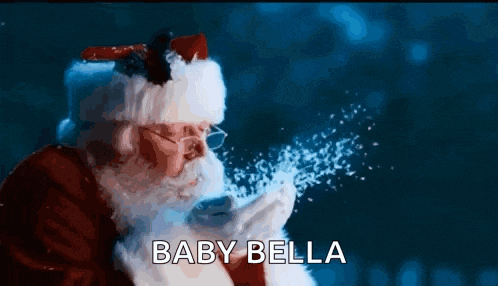 santa claus blowing snow from his hands with the words baby bella written below him