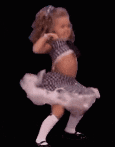 a little girl is dancing in a tutu and socks .