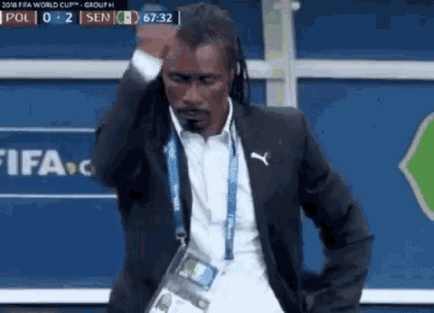 a man in a suit is dancing in front of a fifa logo