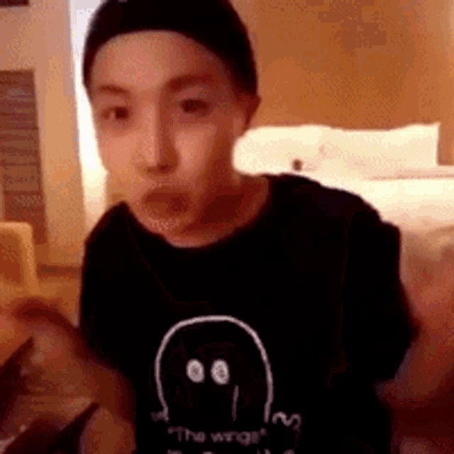 a young man wearing a black shirt with a ghost on it