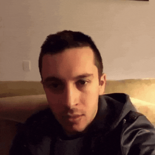 a man is sitting on a couch and making a funny face