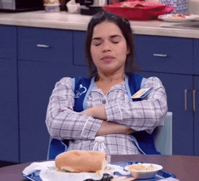 a woman sitting at a table with her arms crossed