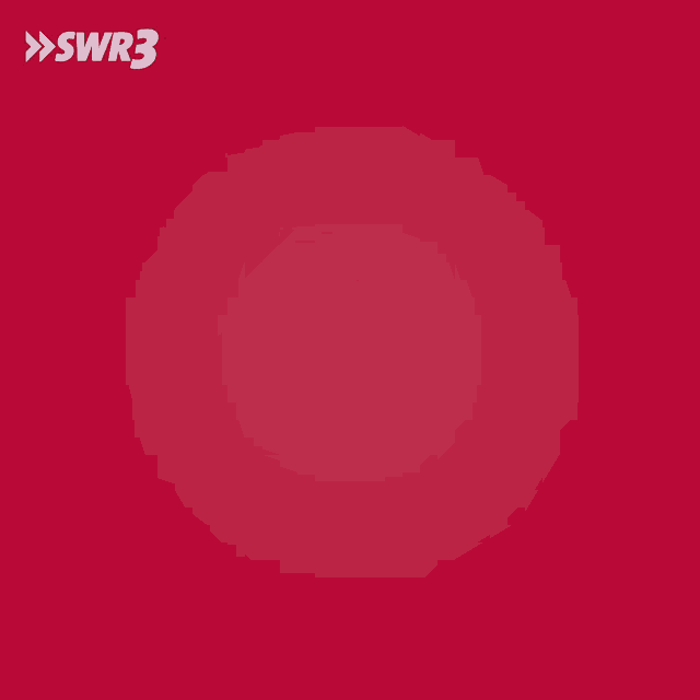 a man wearing a santa hat is holding a gift box in front of a red background with the letters swr3 on it