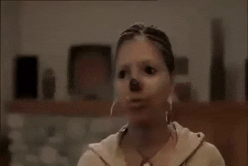 a woman with a mask on her face is sitting in a room .