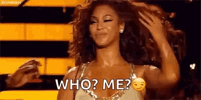 a woman is standing on a stage holding her hair and asking who me .