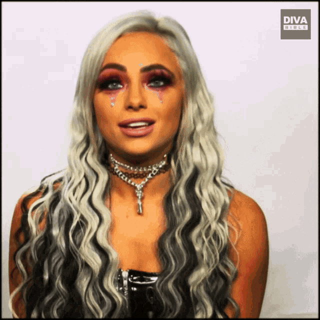 a woman with long blonde hair is wearing makeup and a necklace with the words diva direct on the bottom