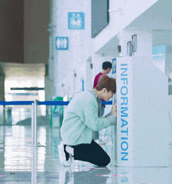 a man is kneeling down in front of a box that says information