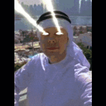 a man in a white robe is taking a selfie with a city in the background .