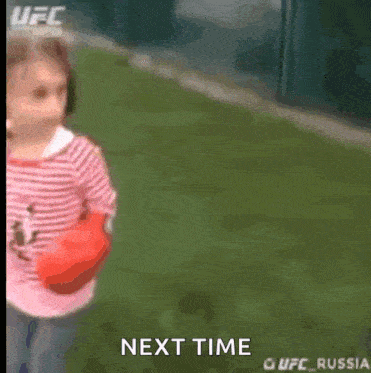 a little girl in a pink and white striped shirt holding a red boxing glove next to the words next time ufc russia