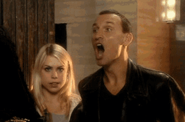 a man and a woman are standing next to each other and the man has his mouth open