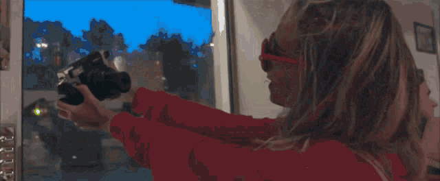 a woman wearing heart shaped sunglasses is biting into a piece of paper