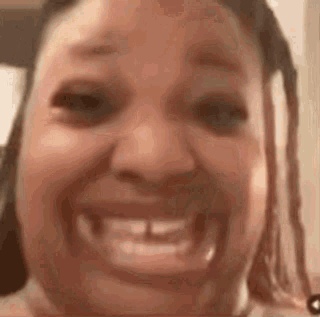 a close up of a woman 's face with a big smile .