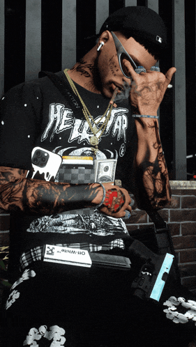 a man wearing a shirt that says hellstar is holding a gun