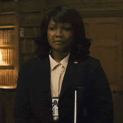 a woman in a suit has a badge that says ' secretary of state '