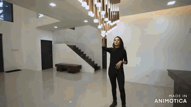 a woman is standing in front of a staircase with the words made in animotica below her