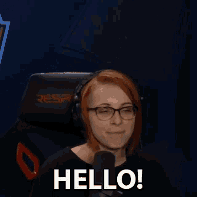 a woman wearing headphones and glasses is sitting in front of a microphone .