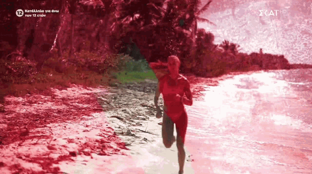 a woman in a red bathing suit is running on a beach with a cat hd logo on the bottom