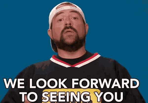a man with a beard is wearing a baseball cap and a black shirt that says we look forward to seeing you