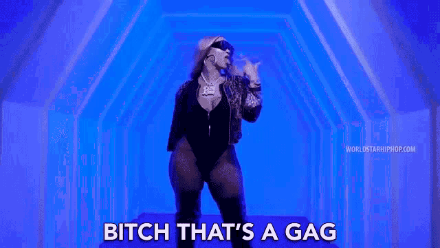 a woman in a black bodysuit is standing in front of a blue background and says `` bitch that 's a gag ''