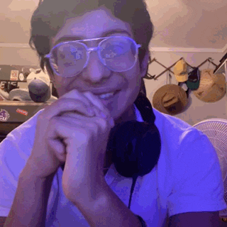 a man wearing glasses and headphones is smiling and looking at the camera
