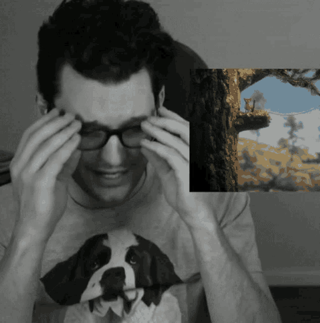 a man wearing glasses and a shirt with a dog on it is crying