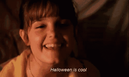 a little girl is smiling with the words `` halloween is cool '' written below her .