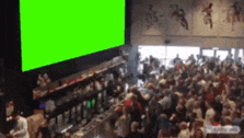 a large crowd of people are gathered in front of a green screen