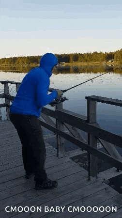 a man in a blue hoodie is fishing on a dock with the caption cmooon baby cmoooon