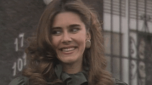 a woman is smiling in front of a wall that has the number 17 on it