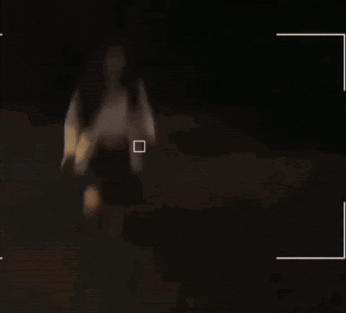 a person is laying on a bed in a dark room with a white border around them .