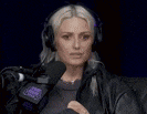 a woman in headphones is sitting in front of a microphone .