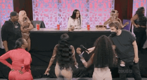 a group of women are kneeling down on the floor in front of a table .