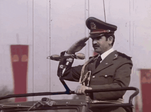a man in a military uniform stands in front of a microphone