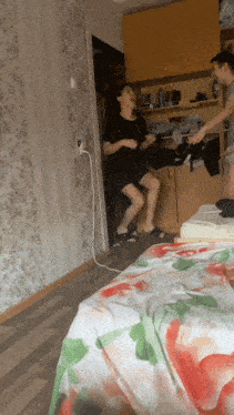 a man and a woman are dancing in a room with a floral table cloth