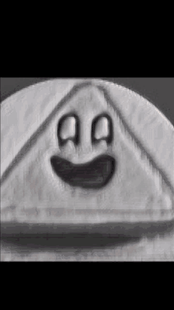 a black and white photo of a triangle with a face drawn on it .