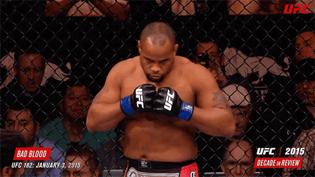 a man wearing ufc gloves is in a cage
