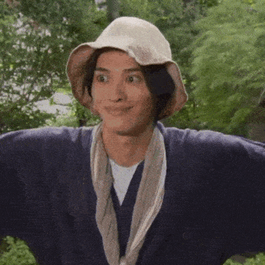 a man wearing a hat and a robe is making a funny face .