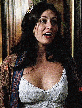 a woman is wearing a white lace bra and a blue robe .