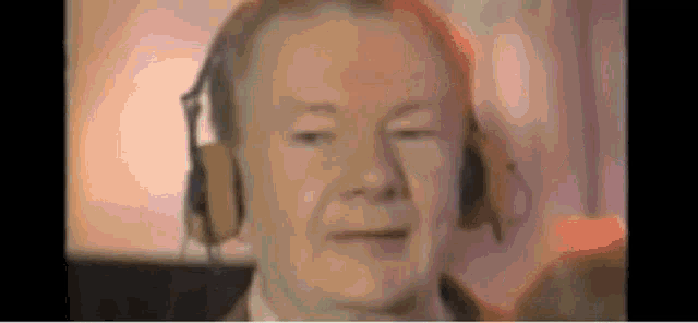 a close up of a man wearing headphones looking at the camera